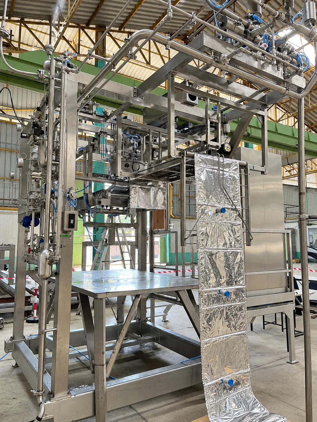 Stainless-steel filling frame with a silver-coloured laminate bag hanging at the front.