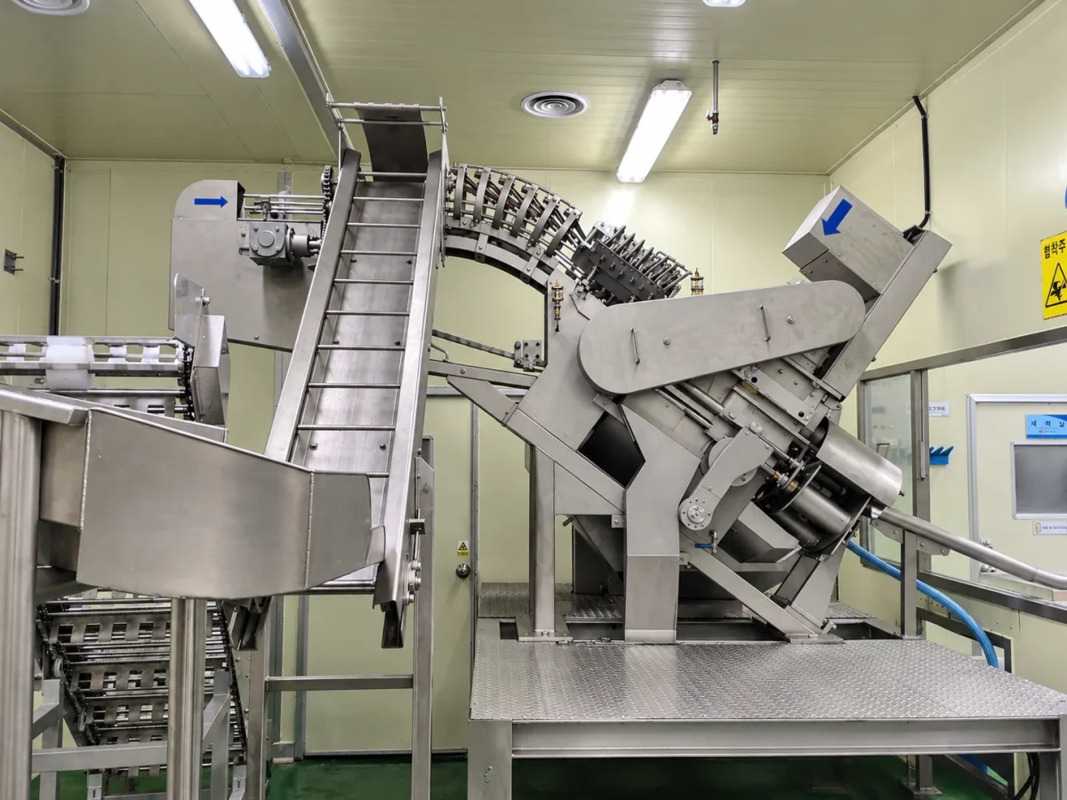 Stainless-steel pineapple preparation equipment with feeding and processing mechanisms.