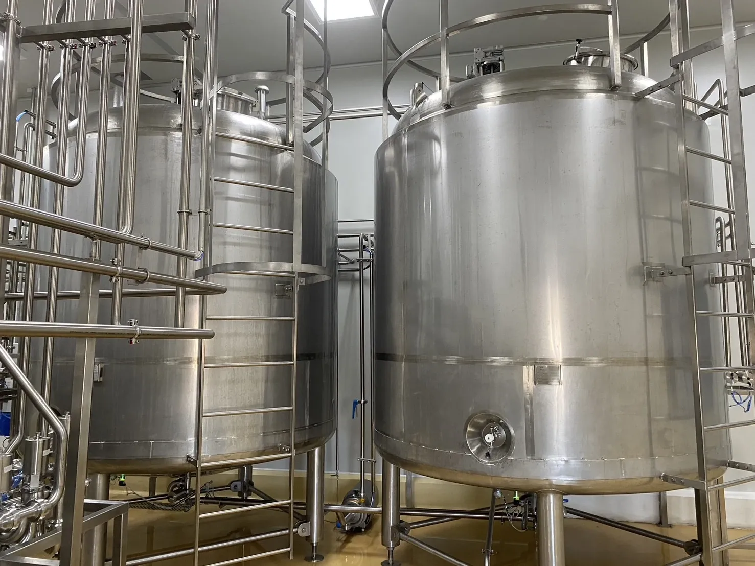 Large stainless-steel storage tanks with connected pipes and support legs.