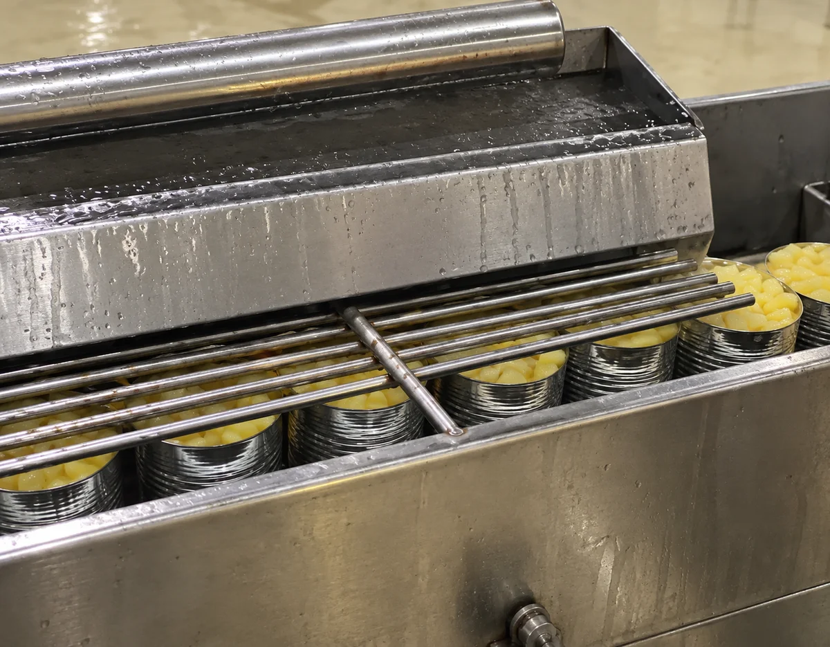 Syrup Filling: Syrup filling section above cans.