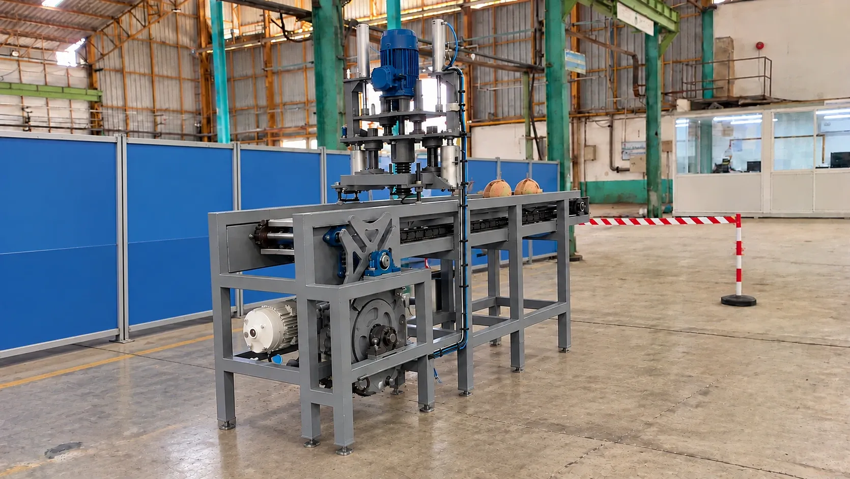 Open-frame coconut drilling machine with drive assemblies and control equipment.