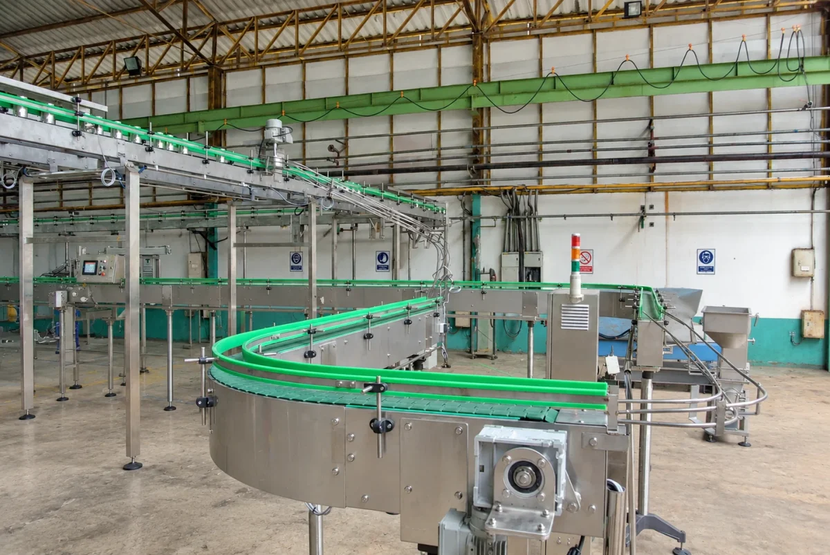 Conveyor system with curved sections and green guide rails.